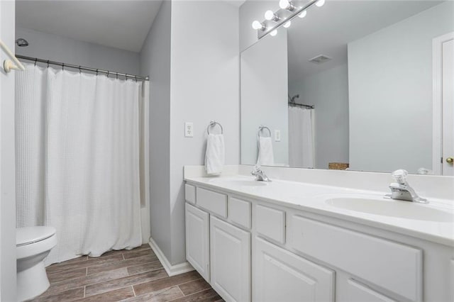 full bathroom featuring a sink, toilet, visible vents, and wood finished floors