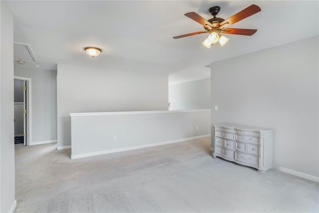 unfurnished room featuring attic access, carpet flooring, and a ceiling fan