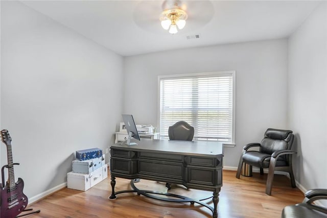 office space with ceiling fan, baseboards, light wood-type flooring, and visible vents