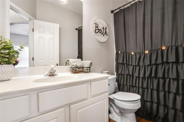 bathroom with toilet, a shower with shower curtain, and vanity