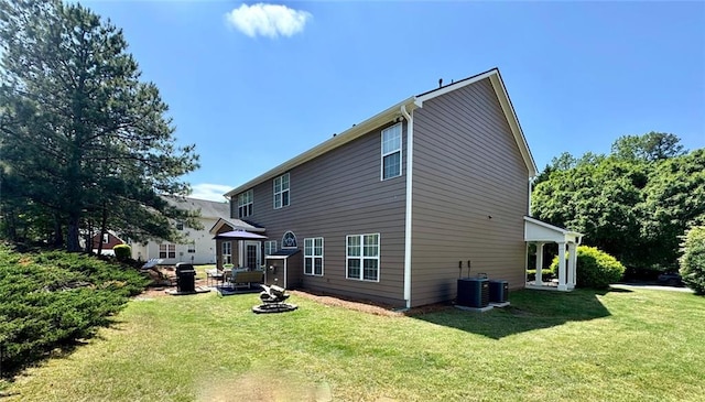 rear view of property featuring cooling unit and a lawn