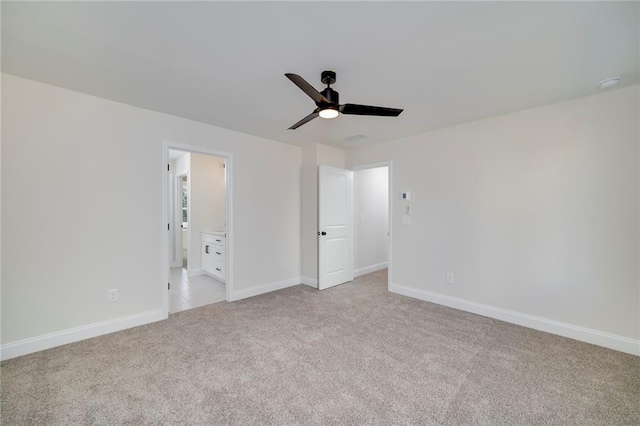 unfurnished bedroom featuring ceiling fan, light colored carpet, and connected bathroom