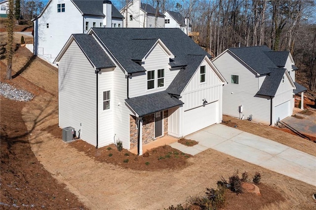 view of front of house featuring a garage and central AC