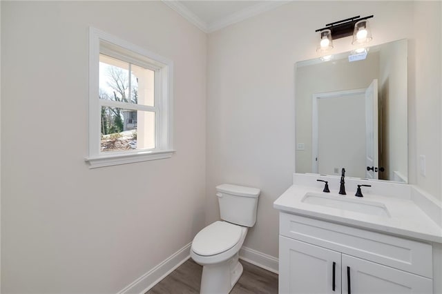 bathroom with wood-type flooring, toilet, vanity, and ornamental molding