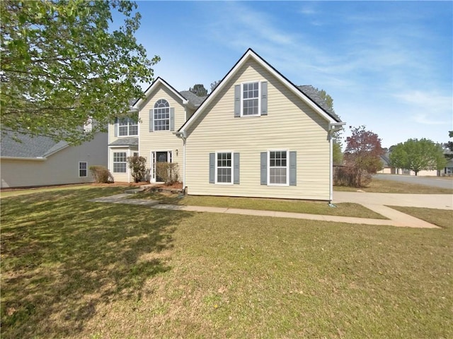 rear view of property featuring a lawn