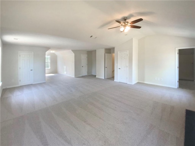 unfurnished living room featuring light colored carpet, vaulted ceiling, ceiling fan, and baseboards