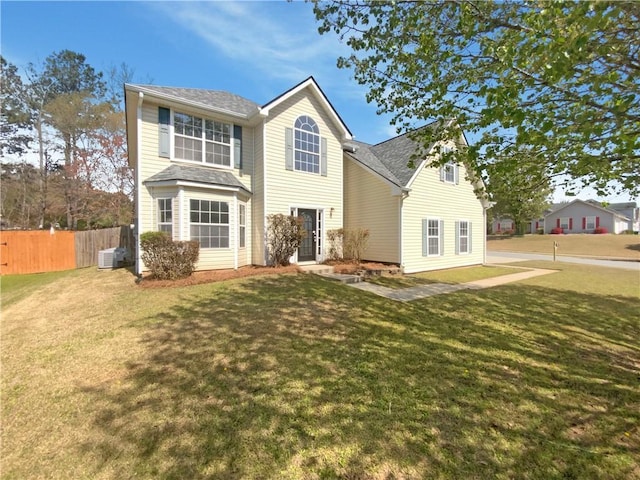 rear view of property with a lawn, fence, and central AC