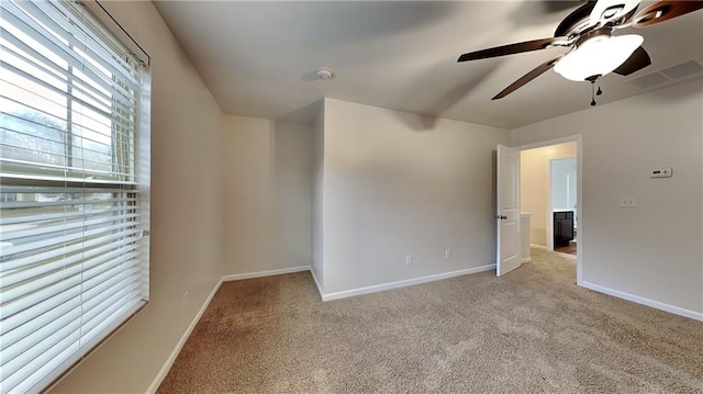 spare room featuring light colored carpet and ceiling fan