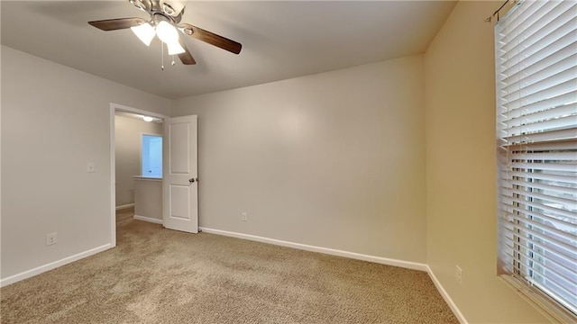 carpeted spare room with ceiling fan