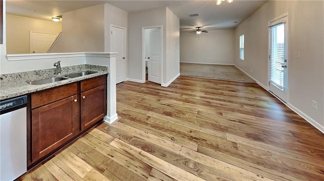 kitchen with light wood-type flooring, light stone countertops, sink, dishwasher, and ceiling fan