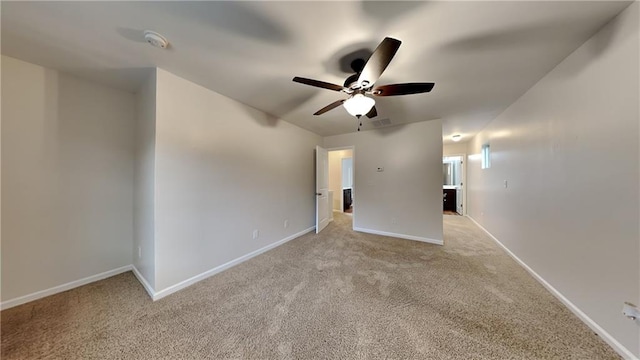 spare room featuring light colored carpet and ceiling fan