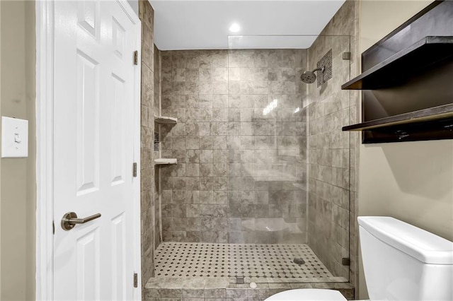 bathroom featuring toilet and a stall shower