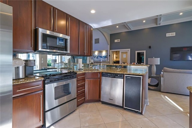 kitchen with light tile patterned flooring, open floor plan, stainless steel appliances, and visible vents