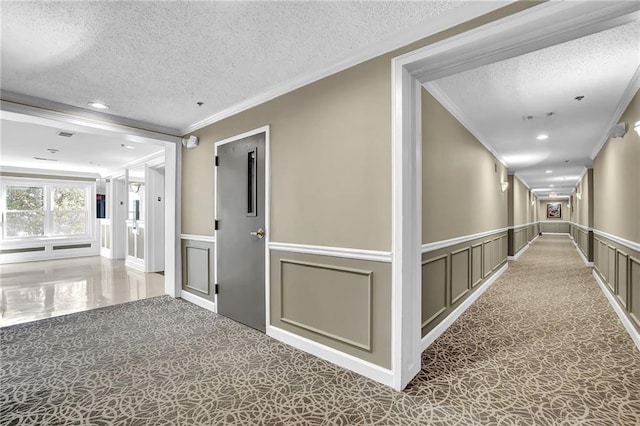 corridor featuring a decorative wall, a textured ceiling, and ornamental molding
