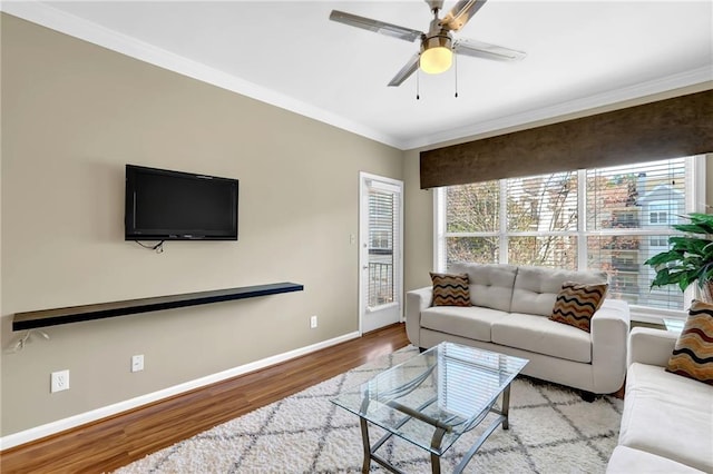 living room featuring crown molding, wood finished floors, and baseboards