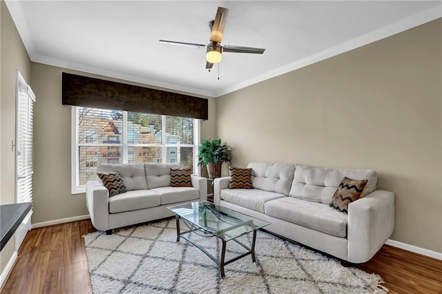 living room with a ceiling fan, crown molding, wood finished floors, and baseboards
