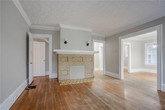 1615 Stokes Ave SW, Atlanta, GA 30310 - unfurnished living room featuring wood-type flooring, baseboards, a textured ceiling, a fireplace, and ornamental molding