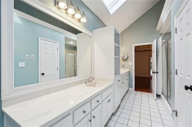 bathroom featuring vanity, tile patterned floors, a shower with shower door, and lofted ceiling with skylight