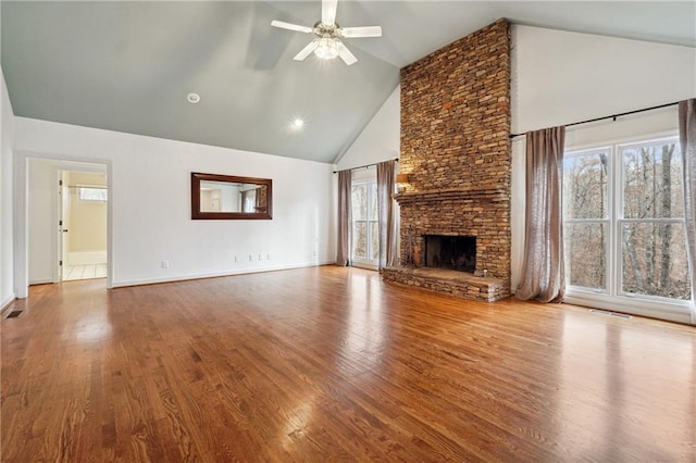 unfurnished living room with hardwood / wood-style flooring, ceiling fan, a fireplace, and high vaulted ceiling