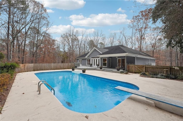 view of pool featuring a patio, a diving board, and french doors