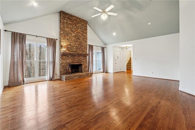 unfurnished living room with ceiling fan, wood-type flooring, a fireplace, and high vaulted ceiling