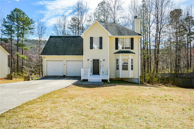 view of front of home with a chimney, a front lawn, concrete driveway, and a garage