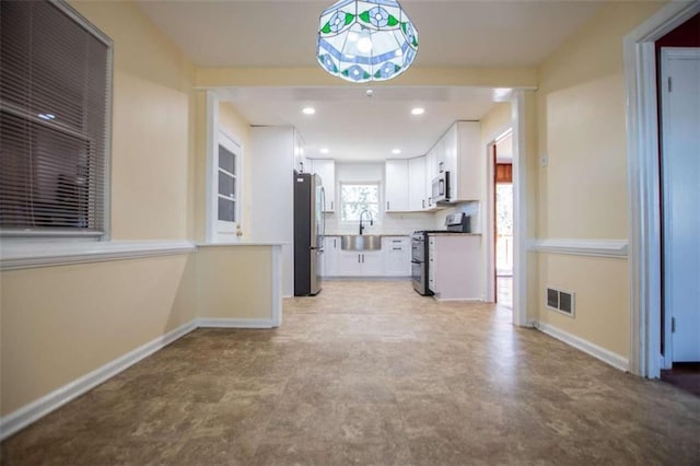 kitchen with appliances with stainless steel finishes, sink, and white cabinets