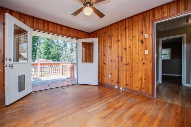 spare room featuring wood-type flooring and wooden walls