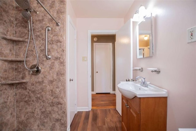 bathroom featuring vanity, hardwood / wood-style flooring, and a tile shower