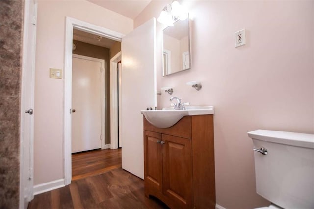 bathroom featuring vanity, wood-type flooring, and toilet