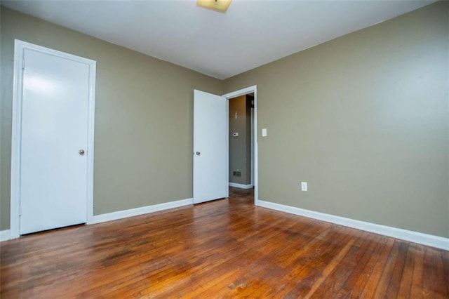 unfurnished room with dark wood-type flooring