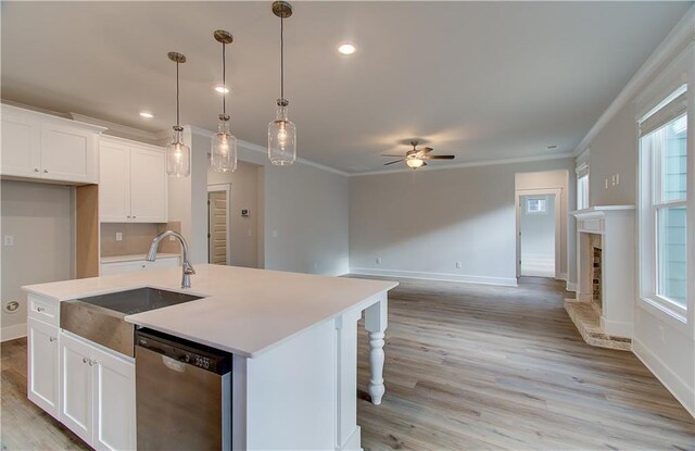 kitchen featuring dishwasher, crown molding, a ceiling fan, and a sink