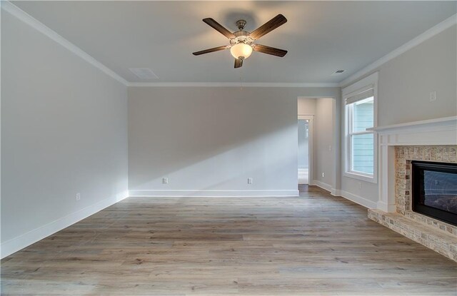 unfurnished living room featuring ceiling fan, crown molding, baseboards, and wood finished floors