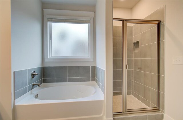 bathroom with a bath and a stall shower