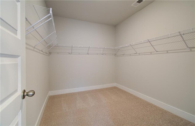 spacious closet featuring visible vents and carpet flooring