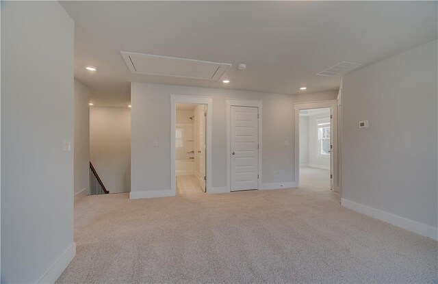 spare room featuring visible vents, recessed lighting, baseboards, light colored carpet, and attic access