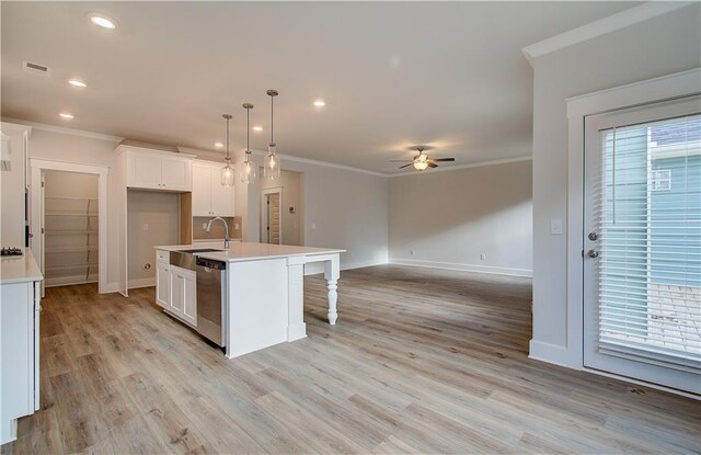 kitchen with a sink, ornamental molding, white cabinets, and stainless steel dishwasher