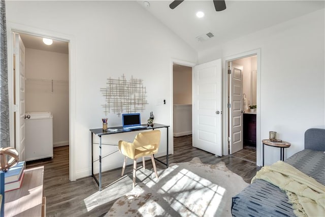 bedroom with a walk in closet, vaulted ceiling, wood finished floors, and visible vents