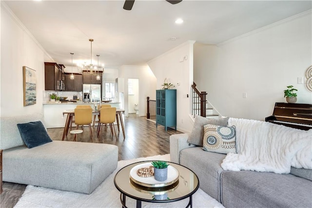 living room featuring hardwood / wood-style flooring, ornamental molding, and ceiling fan