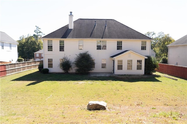 rear view of property featuring a lawn