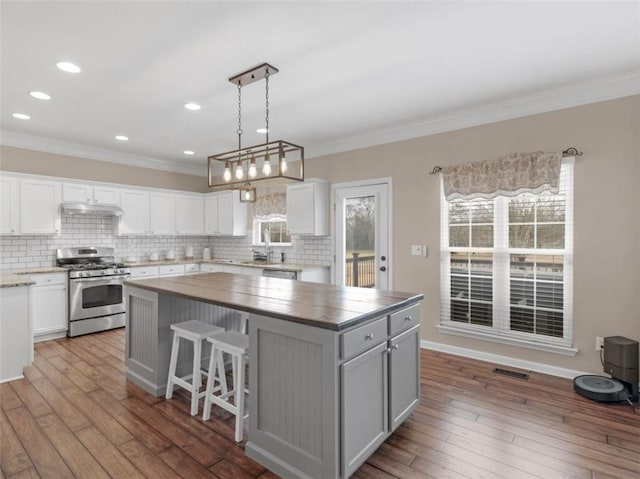 kitchen featuring gas range, a center island, and white cabinets