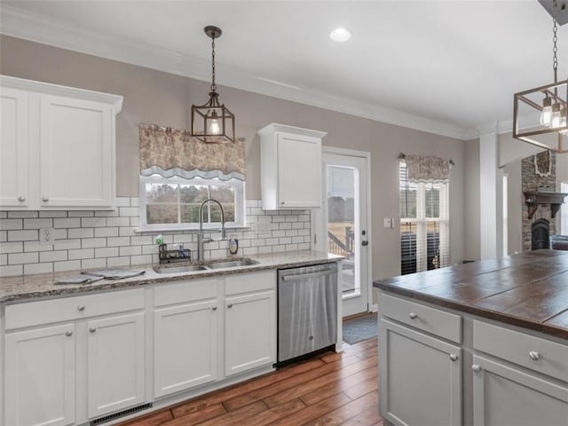 kitchen with white cabinetry, sink, decorative light fixtures, and dishwasher