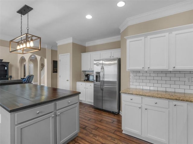 kitchen featuring hanging light fixtures, stainless steel refrigerator with ice dispenser, dark hardwood / wood-style floors, and white cabinets