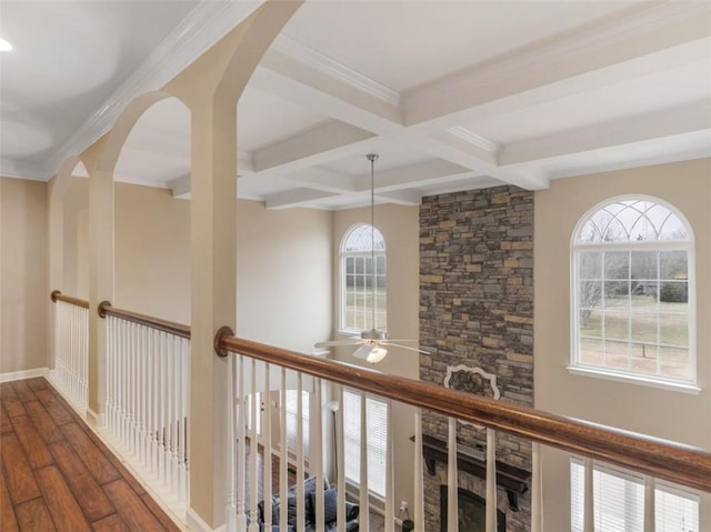 hall featuring dark wood-type flooring, coffered ceiling, beam ceiling, and a wealth of natural light