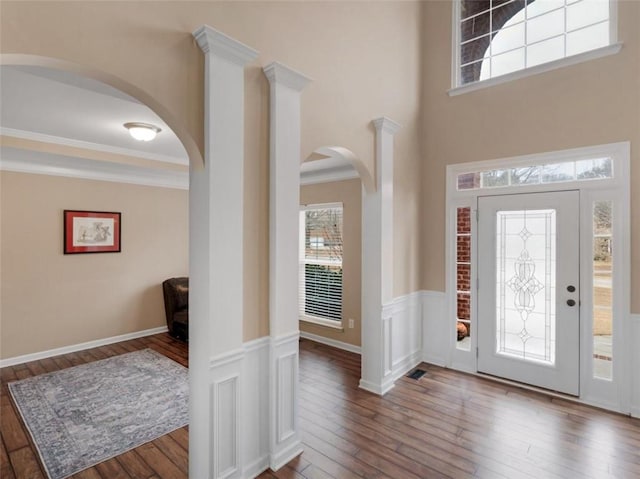 foyer entrance with ornamental molding, hardwood / wood-style floors, and plenty of natural light