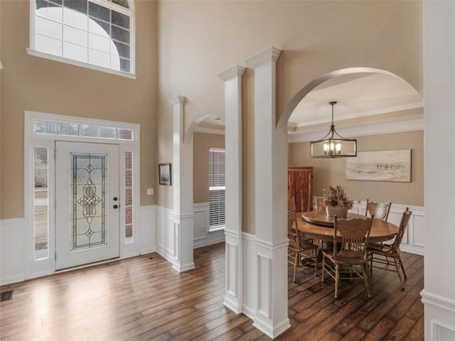 foyer featuring ornamental molding, dark hardwood / wood-style floors, and an inviting chandelier