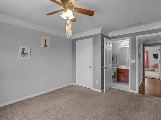 unfurnished bedroom with ornamental molding, light colored carpet, ceiling fan, and ensuite bath