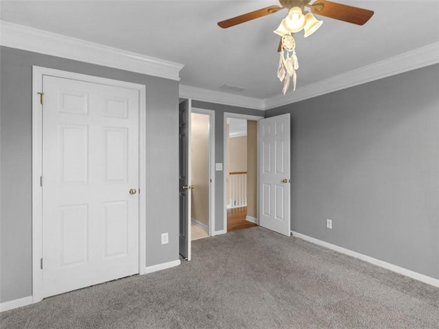 unfurnished bedroom featuring ornamental molding, ceiling fan, and carpet flooring