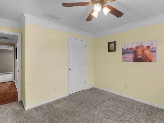 unfurnished bedroom featuring ceiling fan, light colored carpet, and ornamental molding