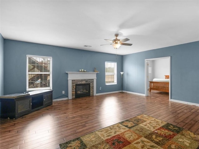 unfurnished living room featuring dark wood-type flooring, a fireplace, and ceiling fan